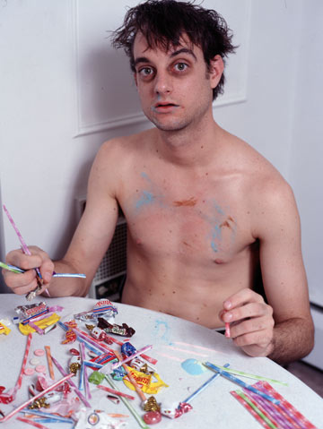 man sitting at table with candy looking cracked out